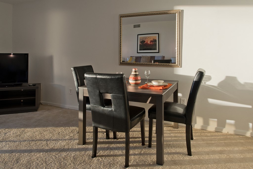 a dining room with a table and chairs and a tv
