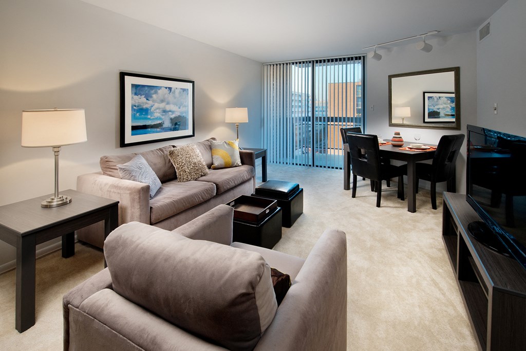 a living room with a couch and a chair and a dining table