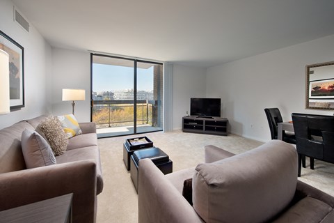 a living room with couches and a tv and a balcony