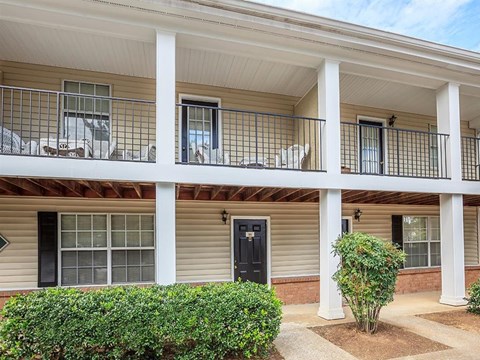 a house with a balcony and a black door