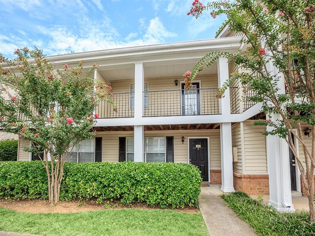 the front of a house with a walkway and trees