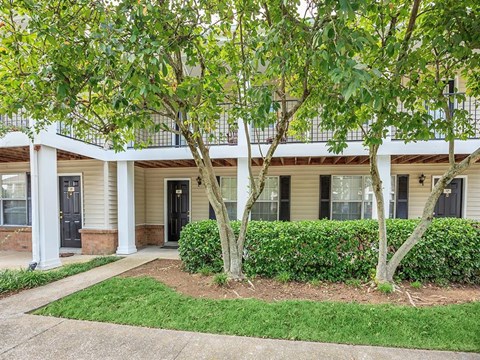 a building with trees and a sidewalk in front of it