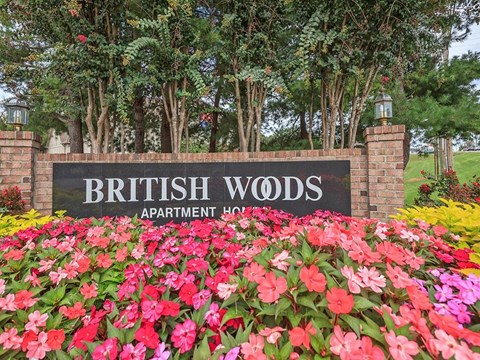 the sign woods apartments is surrounded by flowers