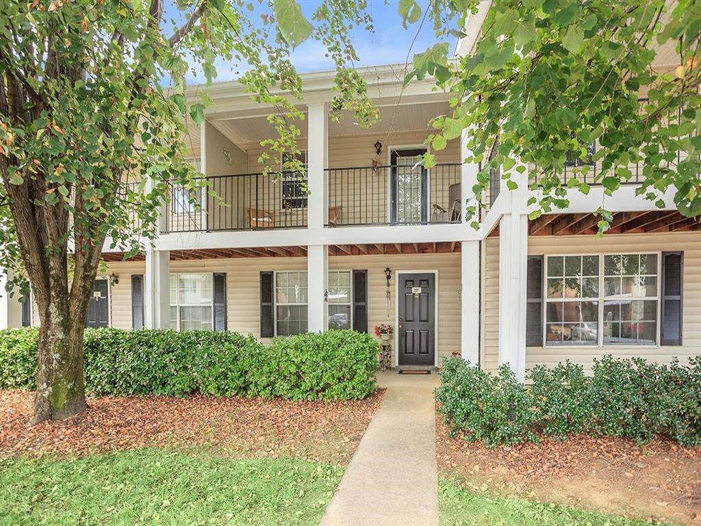 a house with a sidewalk and a tree in front of it