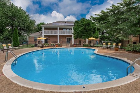 a large blue swimming pool in front of a house