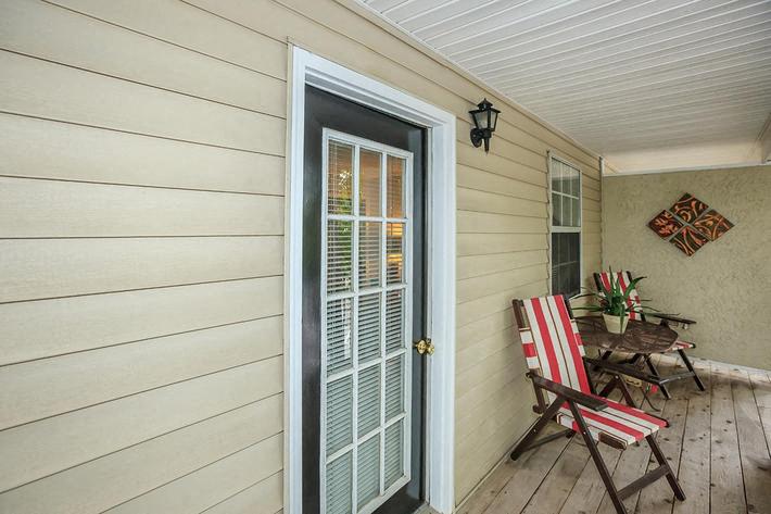 a porch with a table and chairs and a door