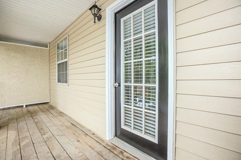 the front porch of a house with a black door