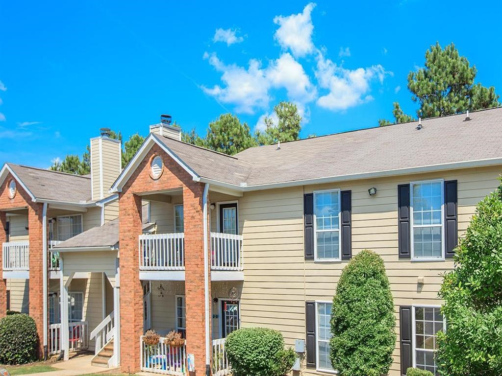 the outlook of an apartment building with trees and a blue sky