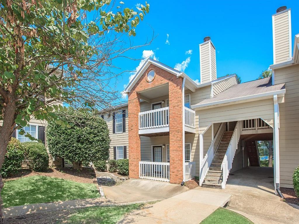 the front of an apartment building with trees and a staircase