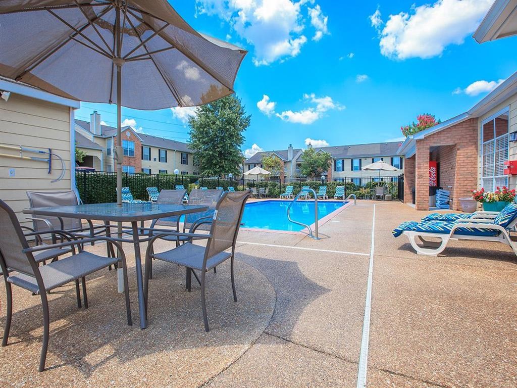 our apartments have a pool and patio with chairs and tables