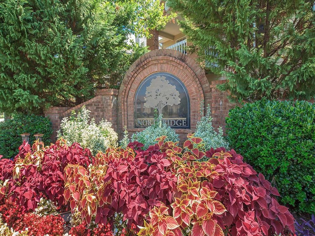 the front of a building with a garden of colorful plants