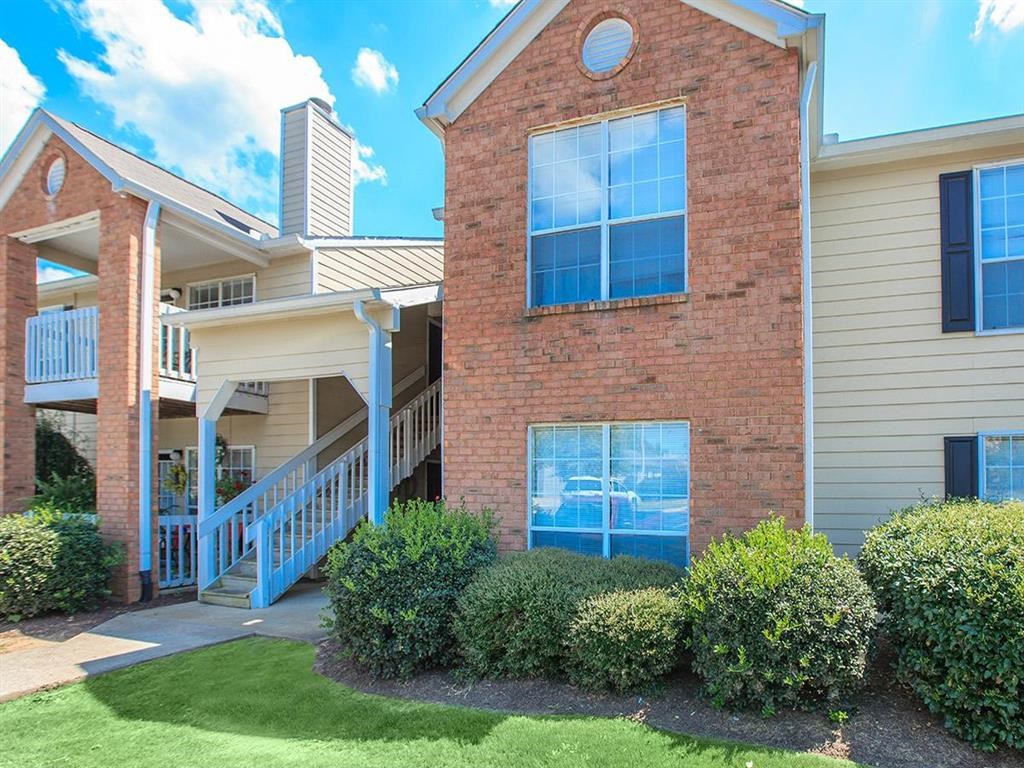 the front of a brick house with a porch and stairs