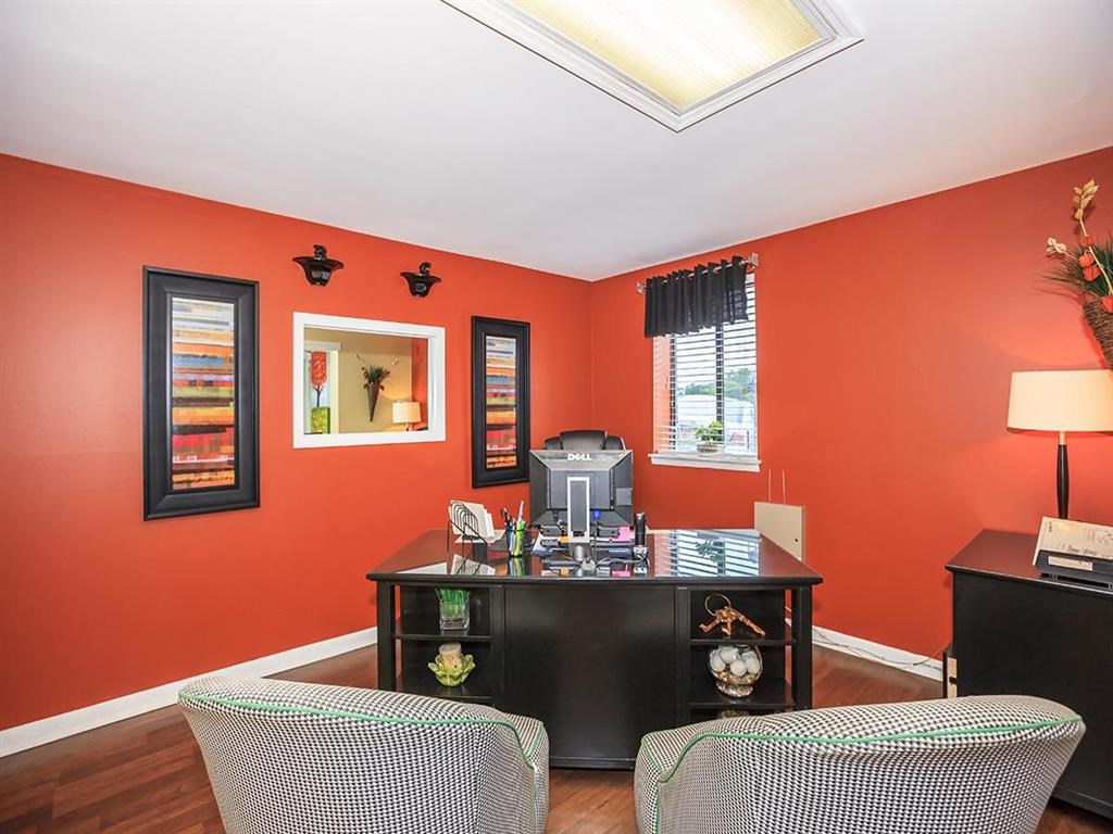 a living room with a desk and chairs