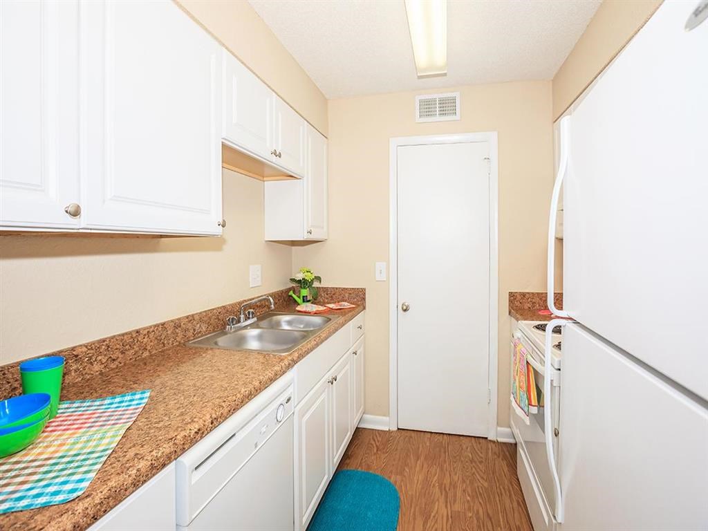 a kitchen with white cabinets and a sink and a refrigerator