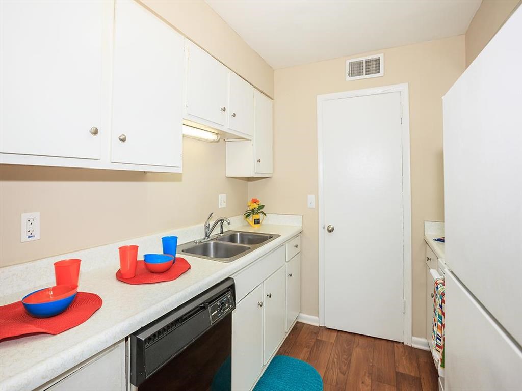 a kitchen with white cabinets and a sink and a dishwasher