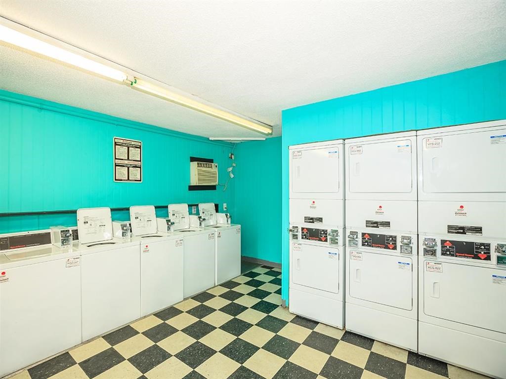 a group of washers and dryers in a room with a checkered