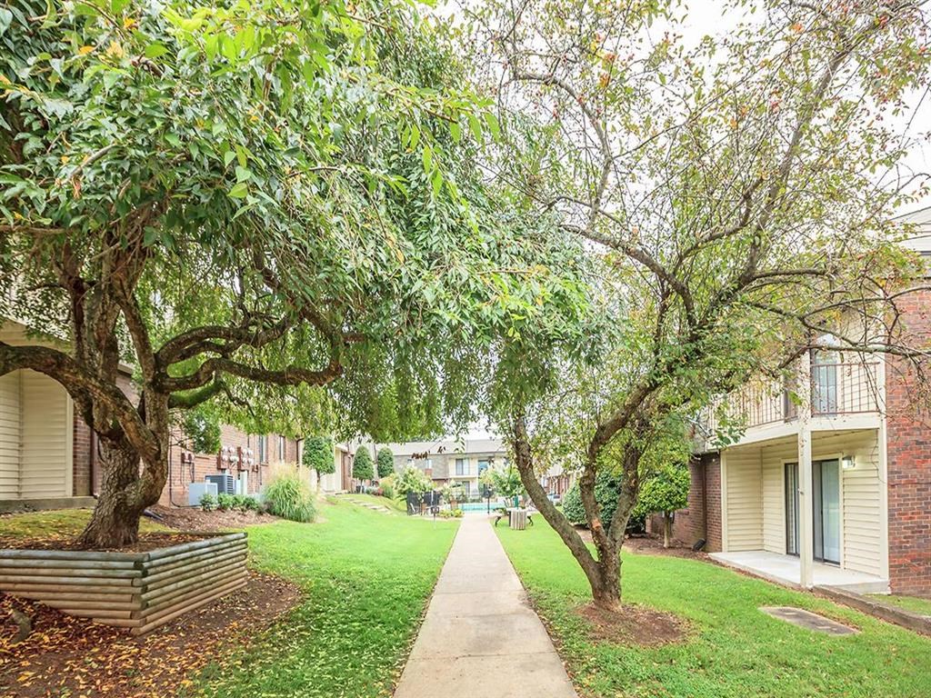 a sidewalk with trees in front of a building