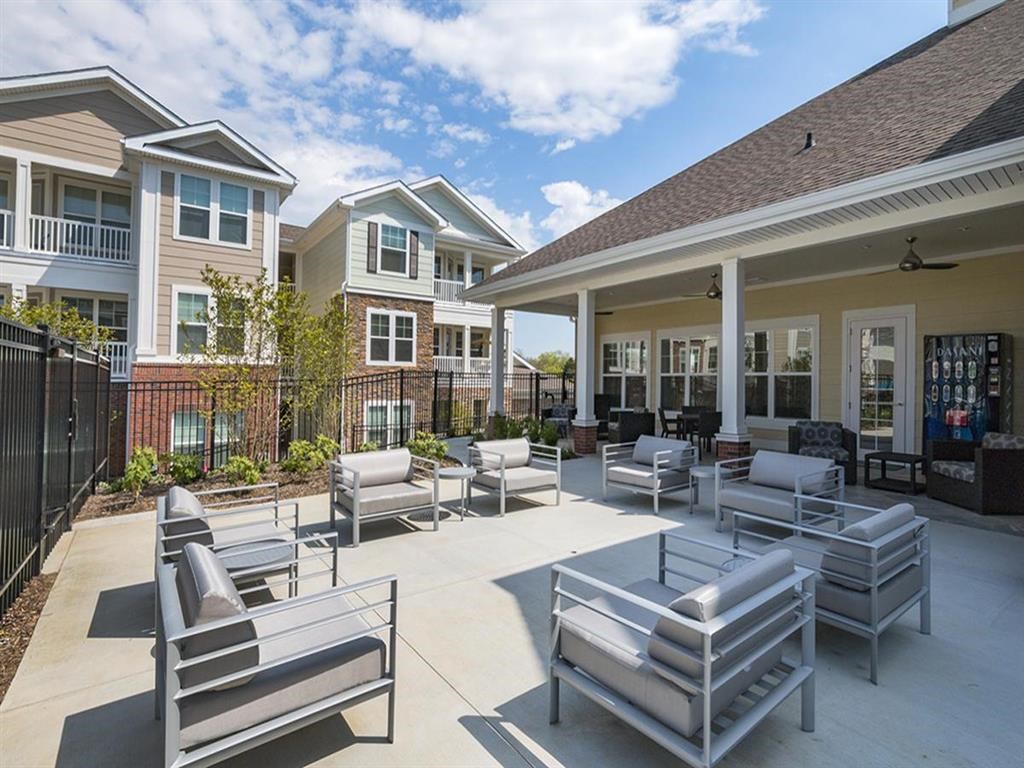 a large patio with chairs and tables in front of houses