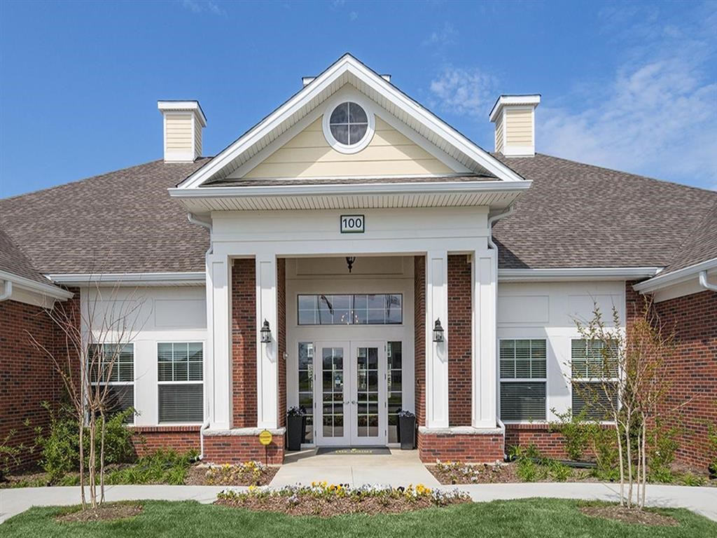 the front entrance of a large brick building with a porch