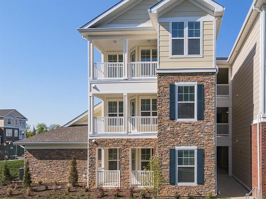 a brick house with a porch and a balcony