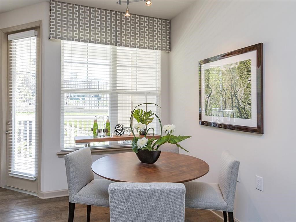 a dining room with a table and chairs and a window