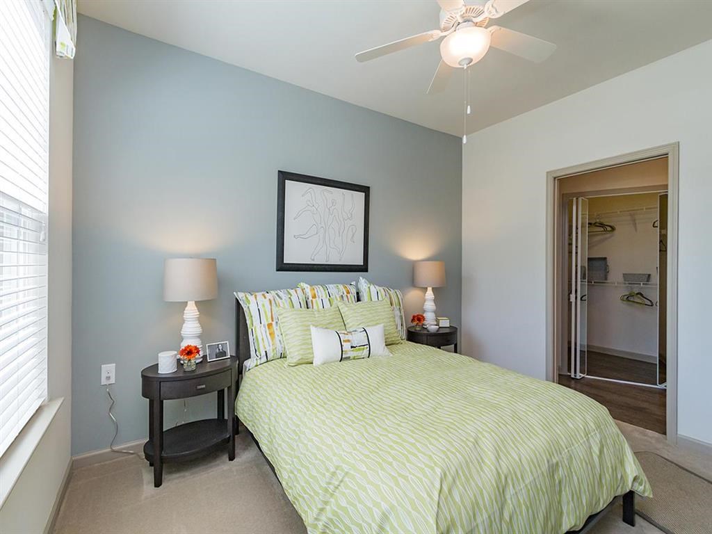 a bedroom with a bed and a ceiling fan