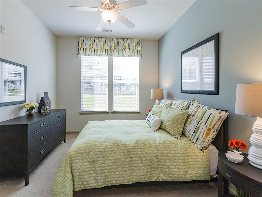a bedroom with a bed and a ceiling fan
