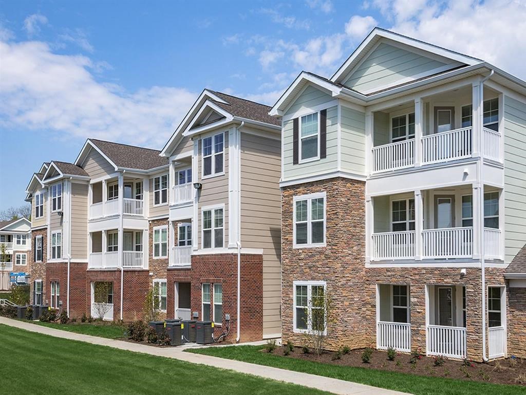a row of apartments with brick and white balconies