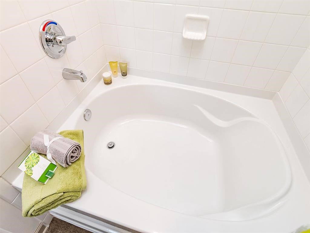 a white bath tub in a bathroom with towels