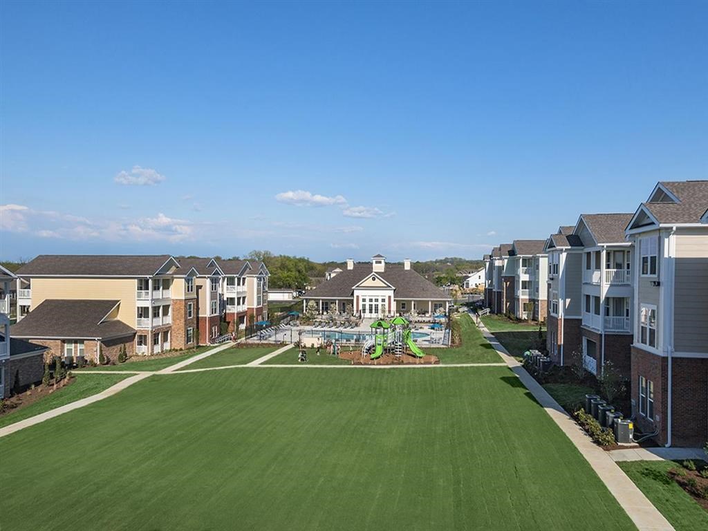 a large green lawn in front of a row of houses