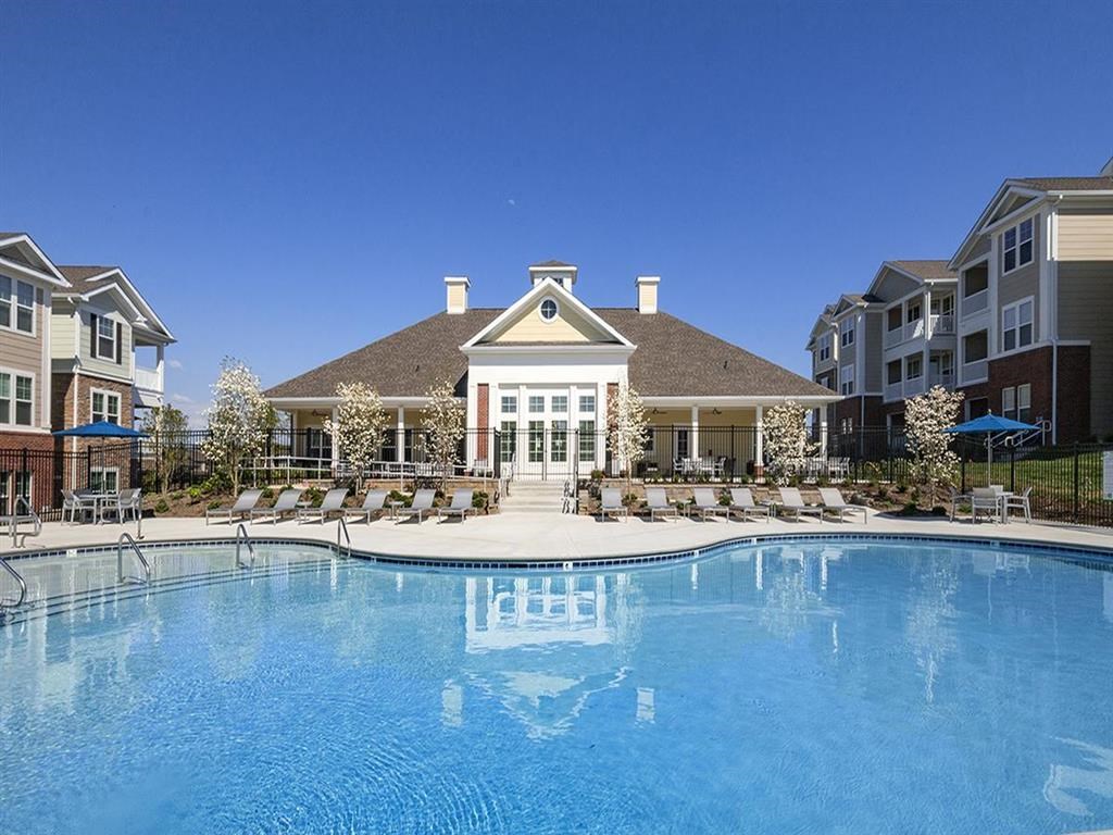 a large swimming pool in front of an apartment building