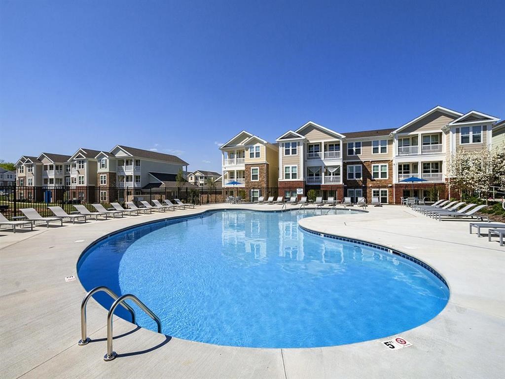 a large swimming pool in front of an apartment building