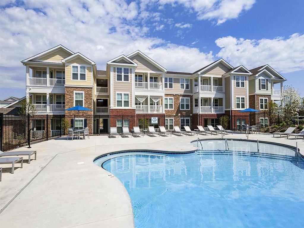 a large swimming pool in front of an apartment building
