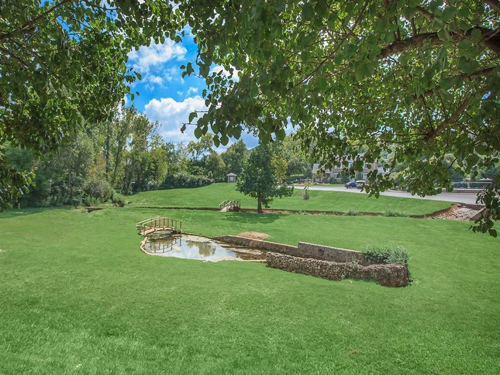 a view of a park with a pond and a bridge