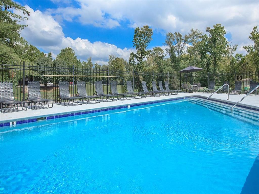 a large pool with chairs and a fence around it
