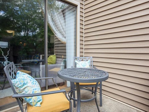 a patio with a table and chairs and a sliding glass door