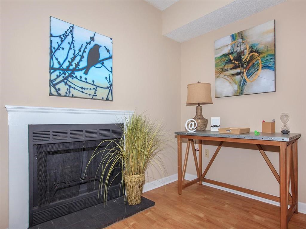 a living room with a fireplace and a desk with a plant