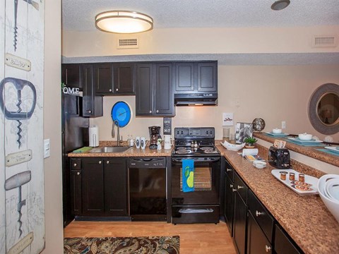 a kitchen with black appliances and granite counter tops