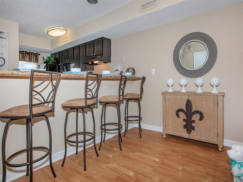a living room with a bar with three chairs