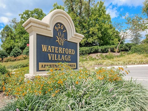 a sign for waterford village on the side of a road