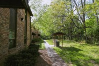a path leading to a brick house with trees