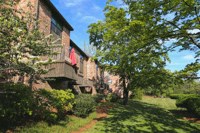 an old house with a red towel on the balcony