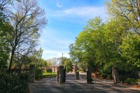 a dirt road with trees and a house in the distance