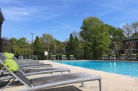 a row of lounge chairs next to a swimming pool