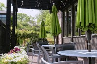 a patio with tables and chairs and green umbrellas