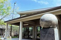 the front entrance of a building with a sculpture of a globe