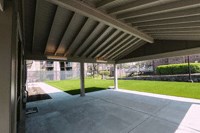 a patio in a building with a lawn in the background