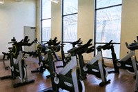 a group of exercise bikes in a room with windows