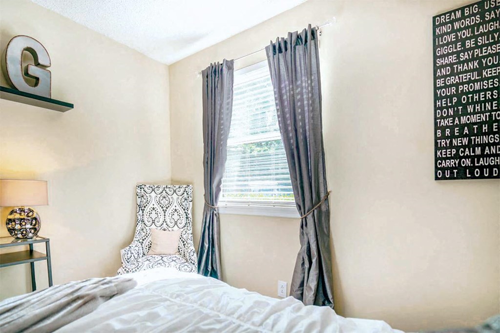 a bedroom with a bed and a window with curtains