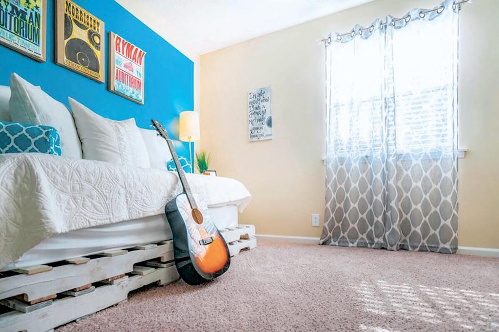 a bedroom with a guitar on the bed